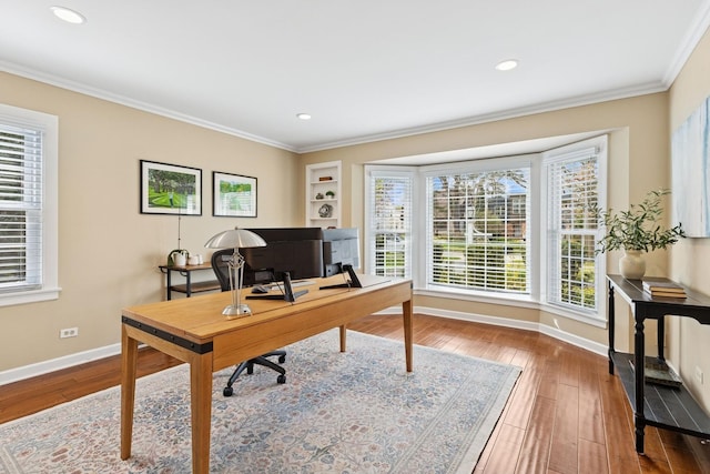 office space featuring wood-type flooring, baseboards, crown molding, and a wealth of natural light