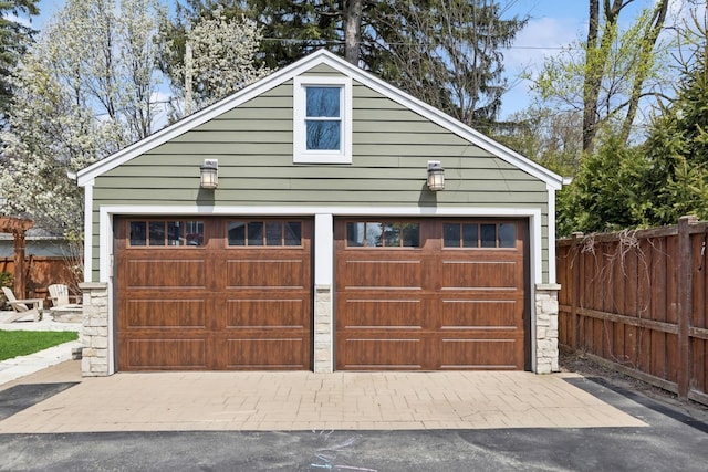 detached garage featuring fence