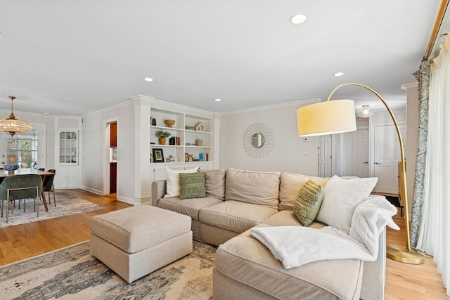 living room featuring crown molding, recessed lighting, and light wood-type flooring