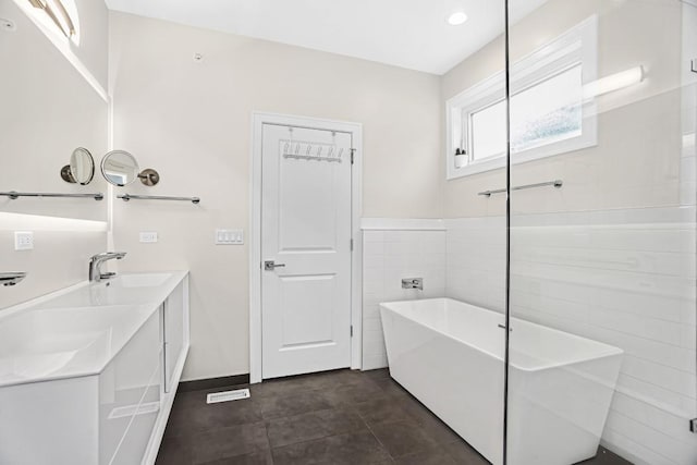 1122 Pitner Ave, Evanston, IL 60202 - full bath featuring a freestanding tub, double vanity, recessed lighting, and tile walls