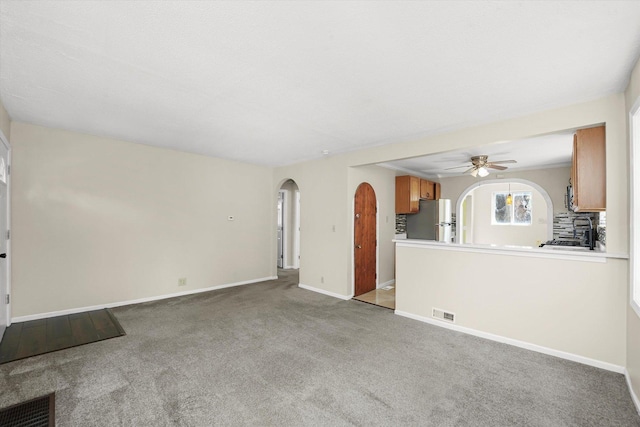 15 N Hillcrest Ave, Fox Lake, IL 60020 - unfurnished living room with ceiling fan, visible vents, arched walkways, baseboards, and carpet floors