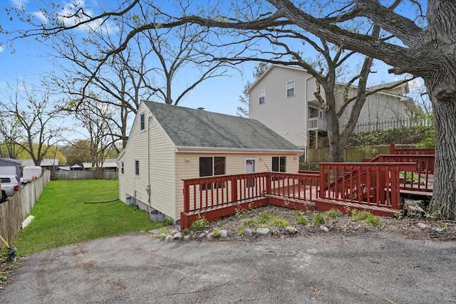 15 N Hillcrest Ave, Fox Lake, IL 60020 - back of property featuring a lawn, roof with shingles, fence, and a wooden deck