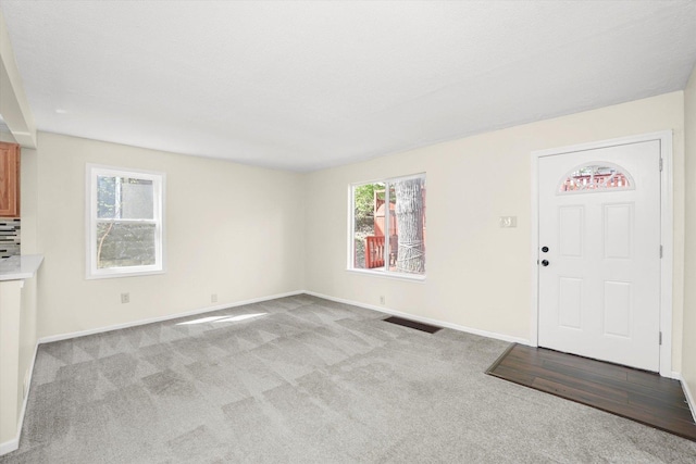 15 N Hillcrest Ave, Fox Lake, IL 60020 - unfurnished living room featuring baseboards, visible vents, and carpet