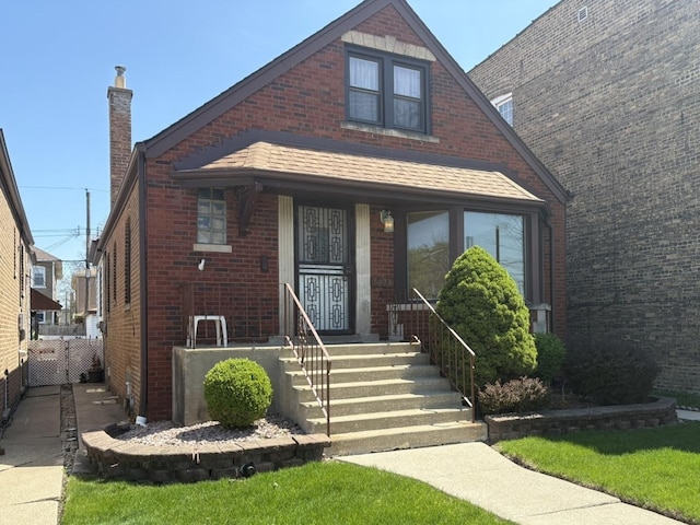 view of front of home featuring brick siding and a chimney