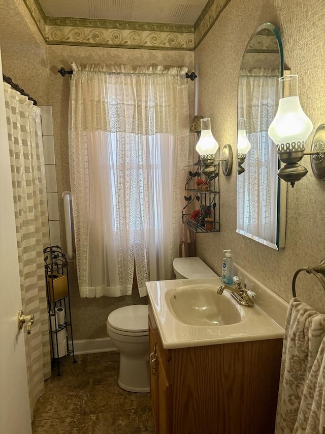 full bath featuring toilet, wallpapered walls, and vanity