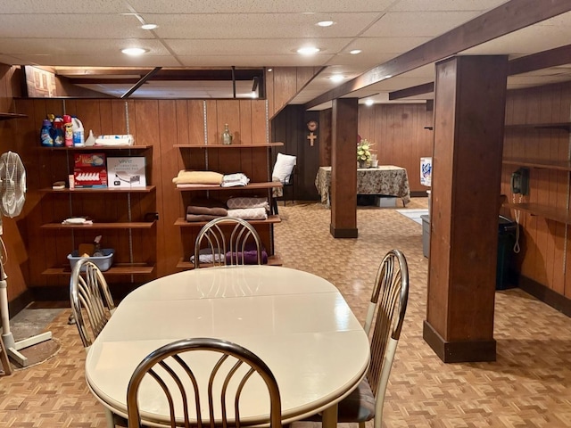 dining area featuring wooden walls and baseboards