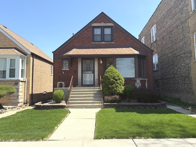 view of front of property with brick siding, a front lawn, and a porch