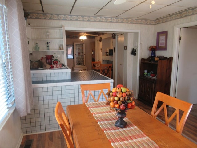 dining area with visible vents, ceiling fan, wood finished floors, and wallpapered walls