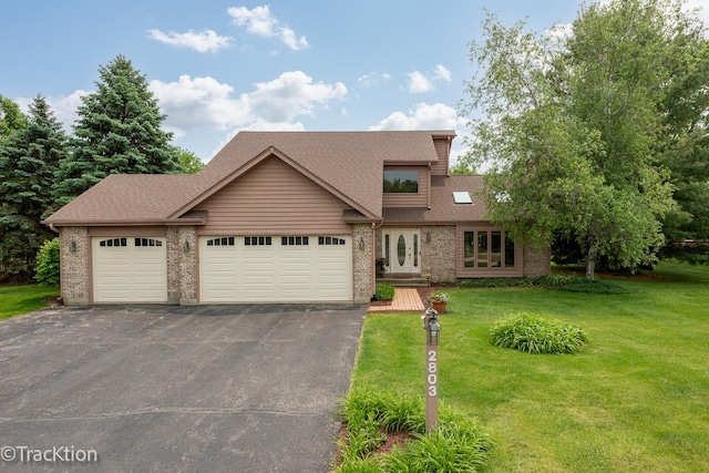 2803 Monterra Dr, Spring Grove, IL 60081 - mid-century home with driveway, a front lawn, an attached garage, brick siding, and roof with shingles