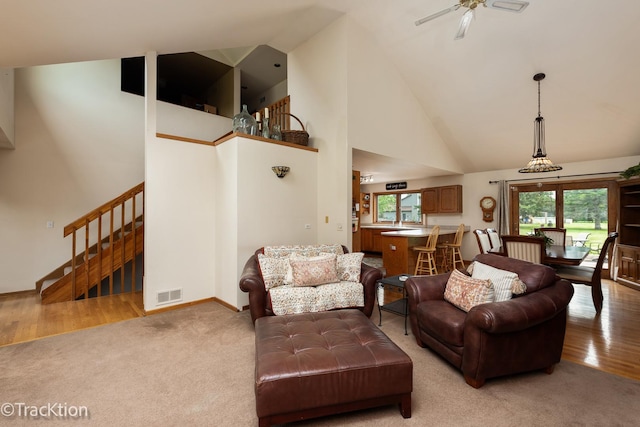 2803 Monterra Dr, Spring Grove, IL 60081 - living room featuring high vaulted ceiling, stairway, ceiling fan, light colored carpet, and baseboards