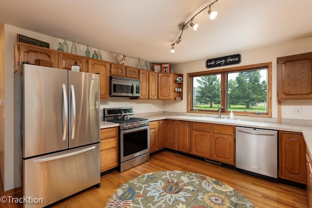 2803 Monterra Dr, Spring Grove, IL 60081 - kitchen featuring stainless steel appliances, a sink, light countertops, brown cabinets, and light wood finished floors
