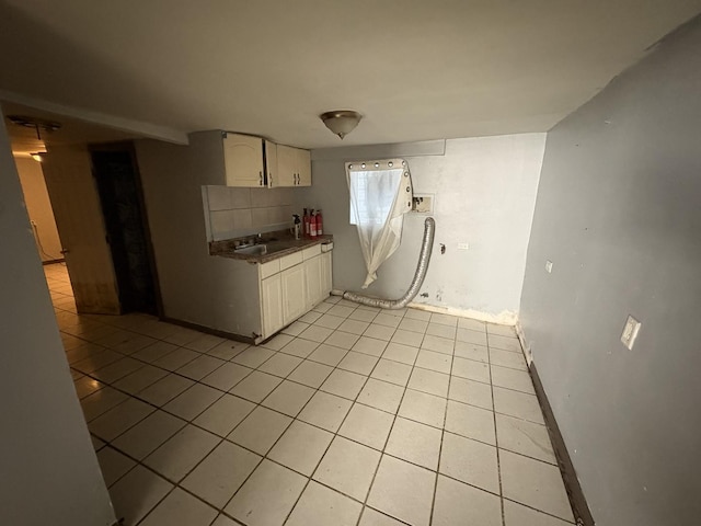 1649 N Latrobe Ave, Chicago, IL 60639 - kitchen with dark countertops, a sink, baseboards, white cabinets, and light tile patterned flooring