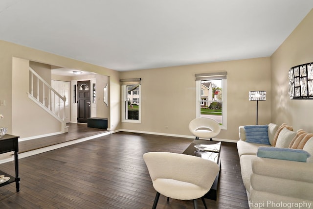 living area featuring stairs, dark wood finished floors, and baseboards