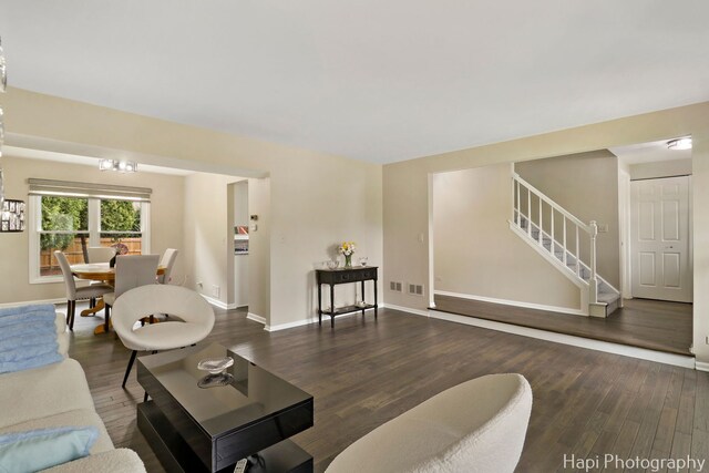 living room with stairway, wood finished floors, and baseboards