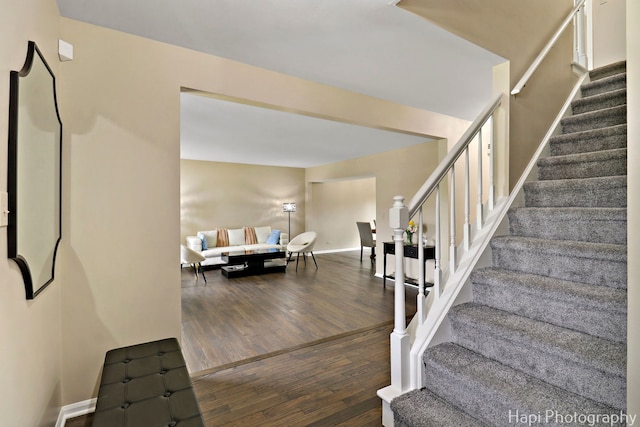 stairway with wood finished floors and baseboards