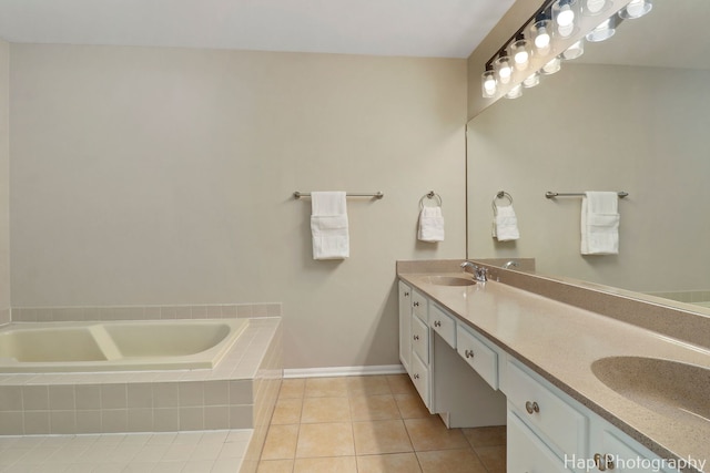 full bath with tile patterned floors, double vanity, a garden tub, and baseboards