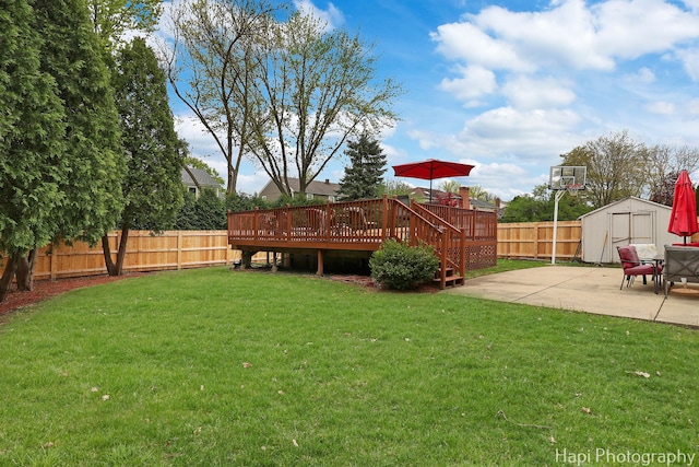 view of yard with a storage unit, a deck, a patio area, and an outdoor structure