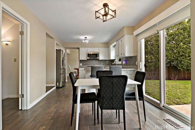 dining area with dark wood-style floors and baseboards