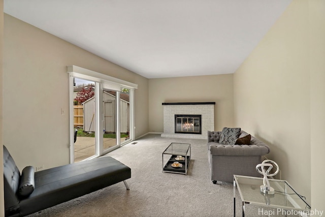 carpeted living room with a brick fireplace and baseboards
