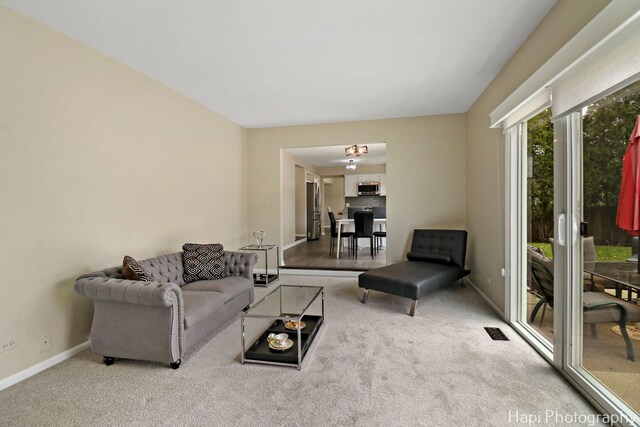 carpeted living area featuring baseboards
