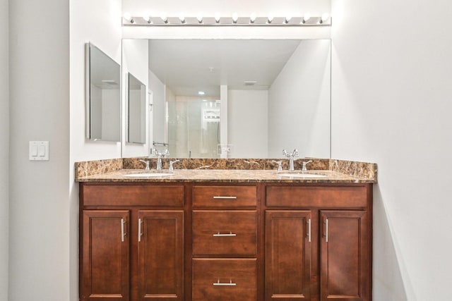 bathroom with double vanity, a stall shower, and a sink