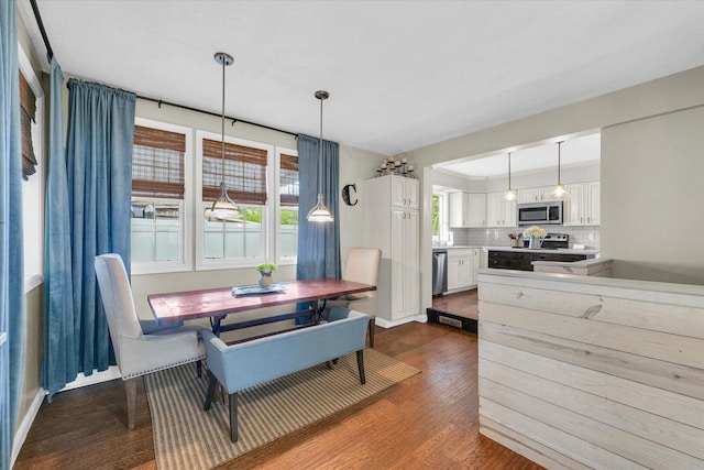 dining room with dark wood-style flooring and plenty of natural light