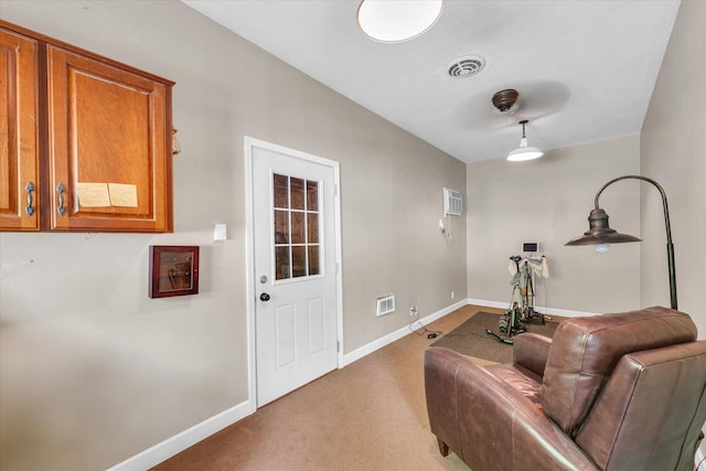 sitting room with baseboards, visible vents, and light colored carpet