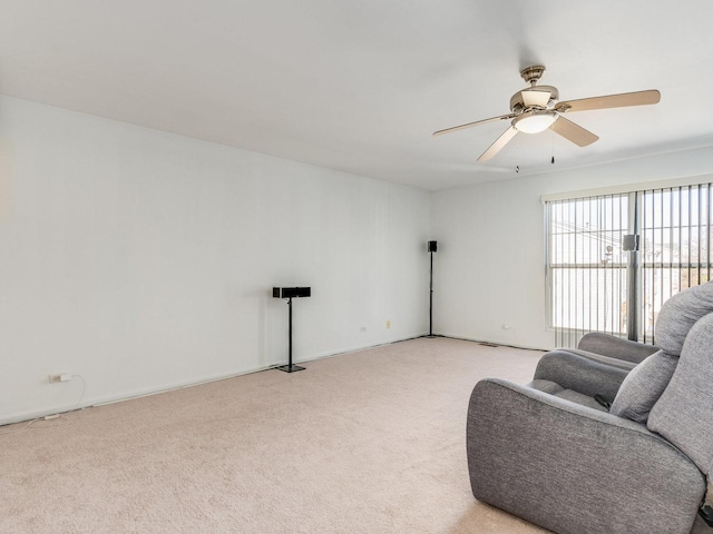 living area featuring light carpet and ceiling fan