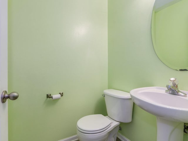 half bathroom with toilet and baseboards