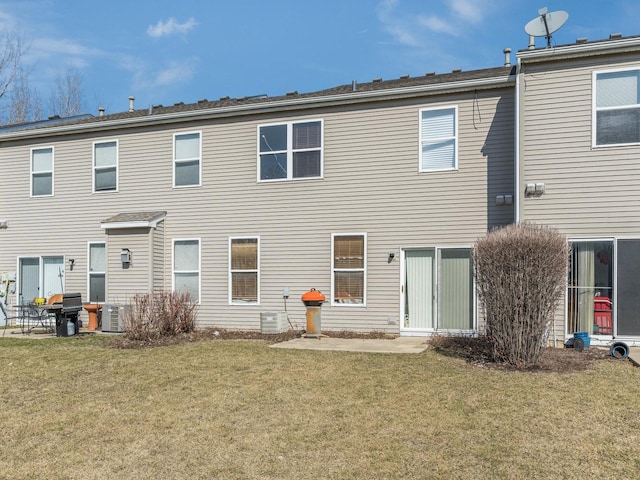 rear view of property featuring cooling unit and a yard