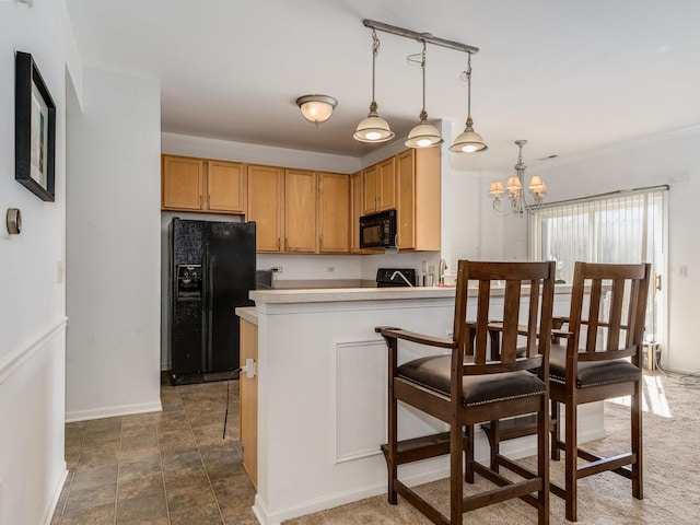 kitchen with a breakfast bar, decorative light fixtures, black appliances, baseboards, and a notable chandelier