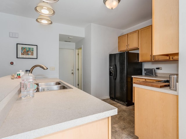 kitchen with light countertops, black refrigerator with ice dispenser, and a sink
