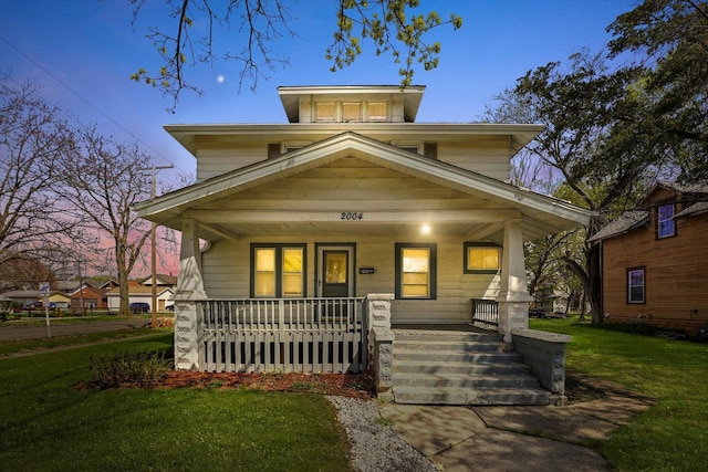 view of front of property featuring a porch and a lawn
