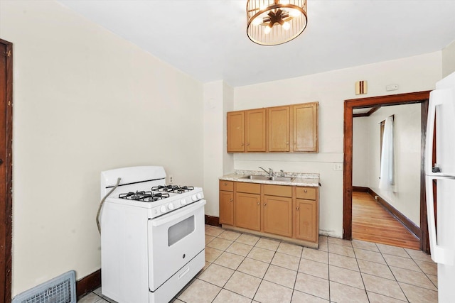 kitchen with light tile patterned floors, a sink, visible vents, light countertops, and gas range gas stove