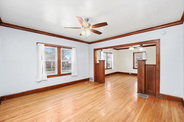 spare room featuring ornamental molding, visible vents, ceiling fan, and light wood-style flooring