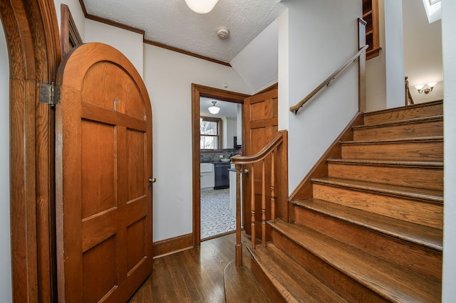 entryway featuring a textured ceiling, dark wood finished floors, stairway, baseboards, and ornamental molding