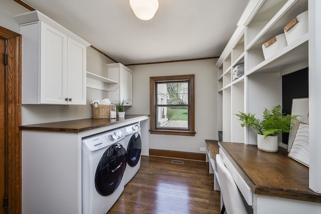 laundry area featuring cabinet space, baseboards, dark wood-type flooring, visible vents, and washing machine and dryer