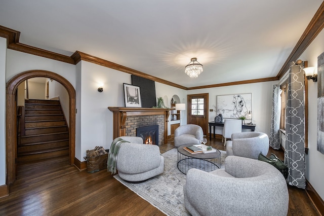 living room featuring baseboards, dark wood-style flooring, a notable chandelier, and a fireplace