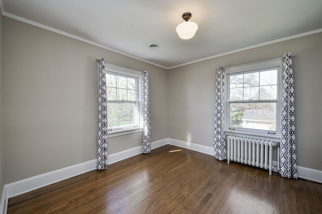 empty room with radiator heating unit, baseboards, ornamental molding, and dark wood-style floors