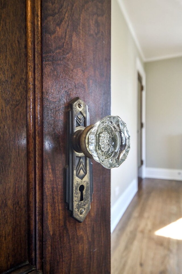 details with baseboards, ornamental molding, and wood finished floors