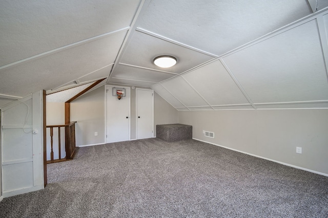 additional living space with carpet floors, baseboards, vaulted ceiling, and visible vents