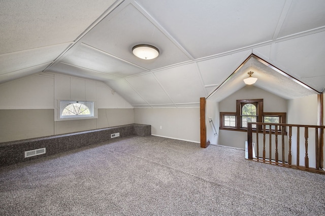 additional living space with visible vents, plenty of natural light, and vaulted ceiling