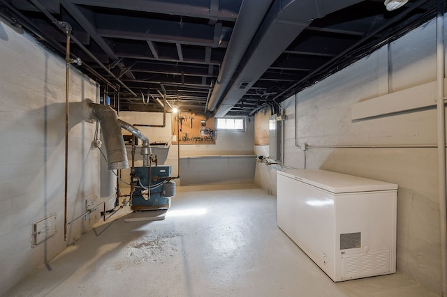 basement featuring a heating unit, electric panel, and refrigerator