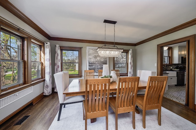 dining room with visible vents, a wealth of natural light, an inviting chandelier, and wood finished floors