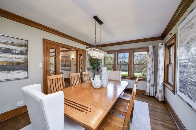dining room with baseboards, dark wood-style flooring, crown molding, and a notable chandelier