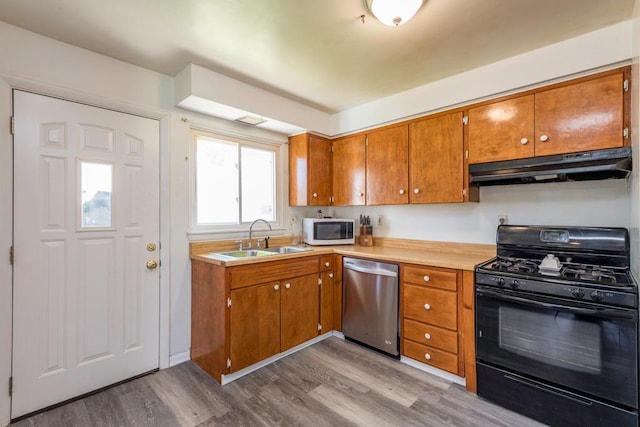 2214 Gilead Ave, Zion, IL 60099 - kitchen featuring a sink, under cabinet range hood, white microwave, black range with gas cooktop, and dishwasher