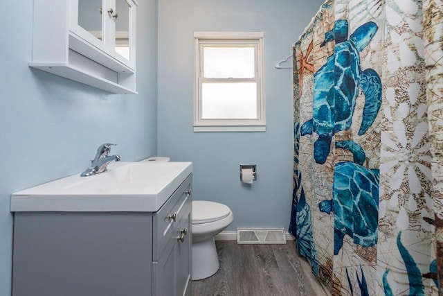 2214 Gilead Ave, Zion, IL 60099 - bathroom with vanity, toilet, visible vents, baseboards, and wood finished floors