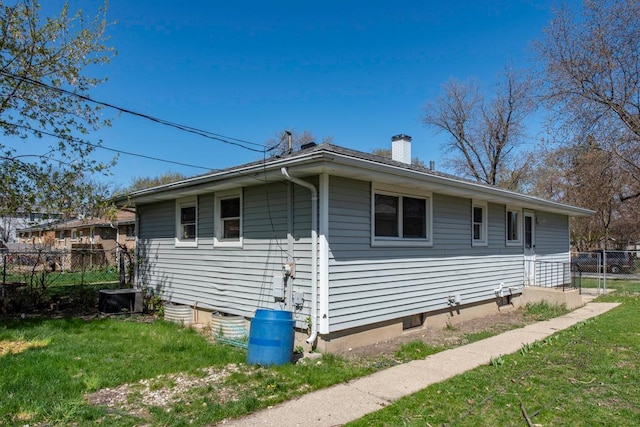 2214 Gilead Ave, Zion, IL 60099 - view of side of home featuring a yard, a chimney, central AC, and fence