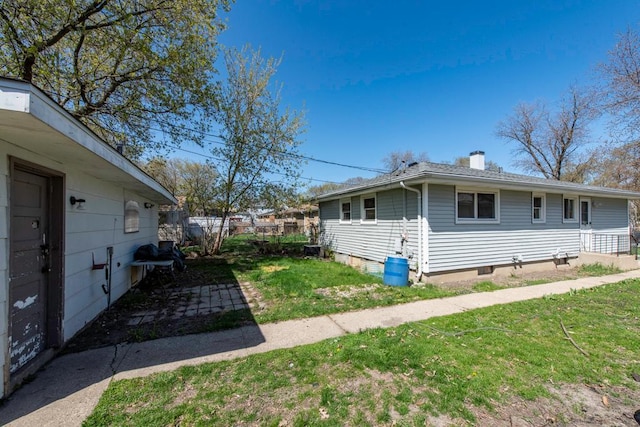 2214 Gilead Ave, Zion, IL 60099 - view of home's exterior featuring a lawn, fence, and a chimney