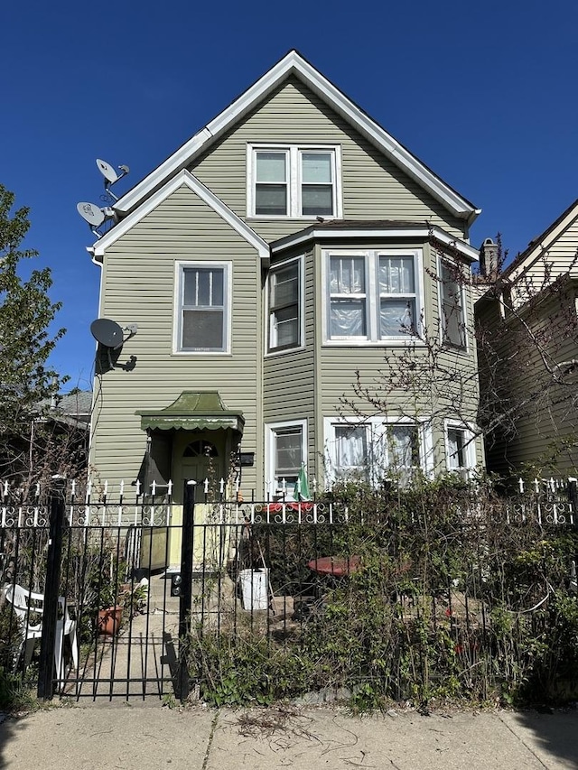 rear view of property featuring a fenced front yard